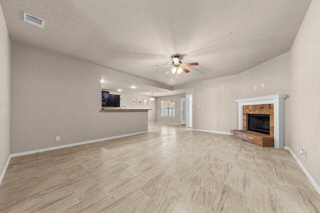 4201 Colonel Dr, Killeen, TX 76549 - unfurnished living room with ceiling fan, a fireplace, and a textured ceiling