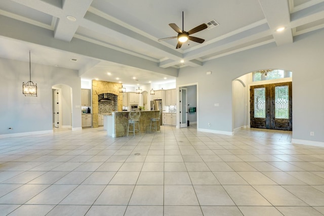 346 Blackbird Dr, Spring Branch, TX 78070 - unfurnished living room featuring arched walkways, french doors, coffered ceiling, ceiling fan, and beam ceiling