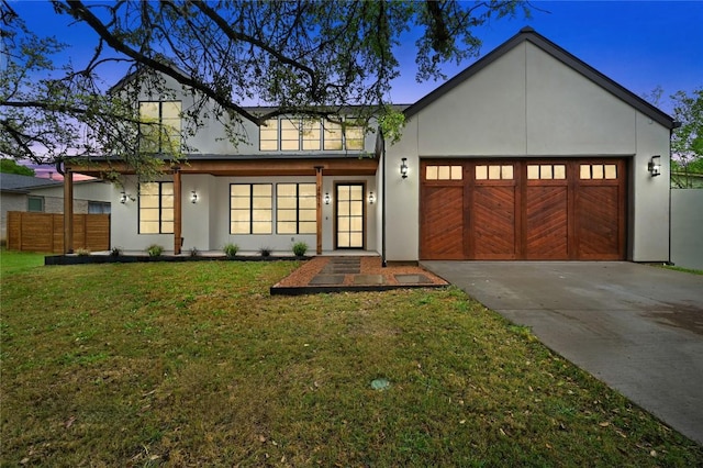2635 Barton Hills Dr, Austin, TX 78704 - view of front of home with an attached garage, driveway, stucco siding, and a front lawn