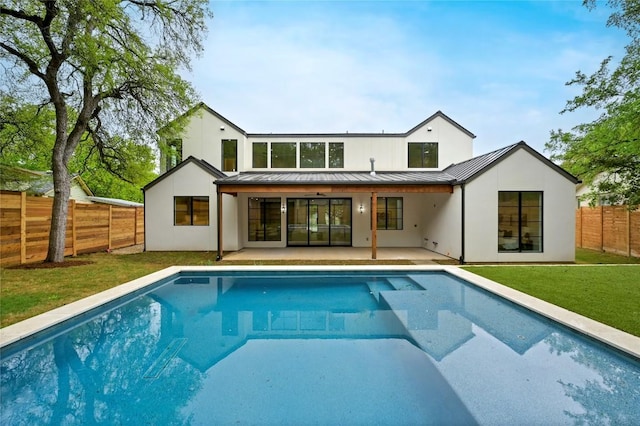 2635 Barton Hills Dr, Austin, TX 78704 - rear view of house with a standing seam roof, a fenced backyard, a patio area, stucco siding, and a metal roof