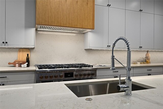 2635 Barton Hills Dr, Austin, TX 78704 - kitchen with stainless steel range with gas cooktop, ventilation hood, decorative backsplash, and light stone counters