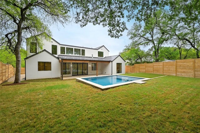 2635 Barton Hills Dr, Austin, TX 78704 - back of property featuring a standing seam roof, a fenced backyard, a metal roof, and stucco siding
