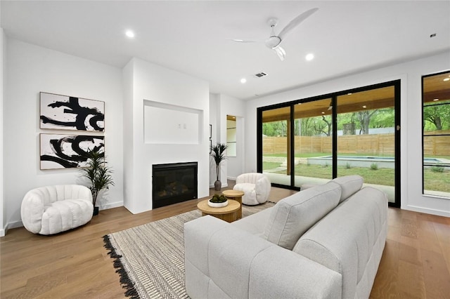 2635 Barton Hills Dr, Austin, TX 78704 - living room featuring wood finished floors, a glass covered fireplace, ceiling fan, and recessed lighting