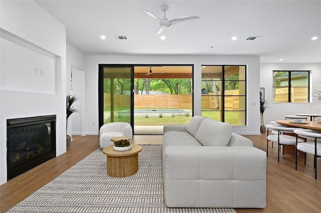 2635 Barton Hills Dr, Austin, TX 78704 - living room with a glass covered fireplace, wood finished floors, a ceiling fan, and recessed lighting