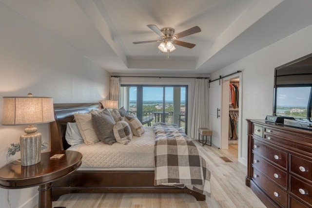3305 Close Call, Horseshoe Bay, TX 78657 - bedroom with a tray ceiling, a walk in closet, light wood finished floors, ceiling fan, and a closet