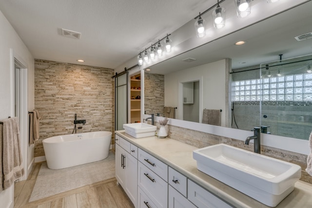 3305 Close Call, Horseshoe Bay, TX 78657 - full bath with a shower stall, double vanity, a soaking tub, recessed lighting, and wood finished floors
