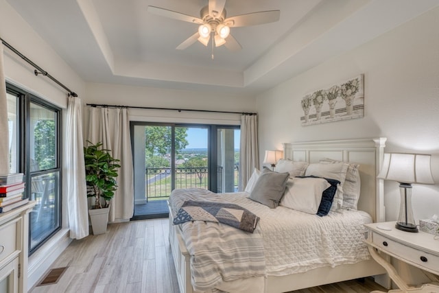 3305 Close Call, Horseshoe Bay, TX 78657 - bedroom with a tray ceiling, access to exterior, light wood-style floors, and ceiling fan