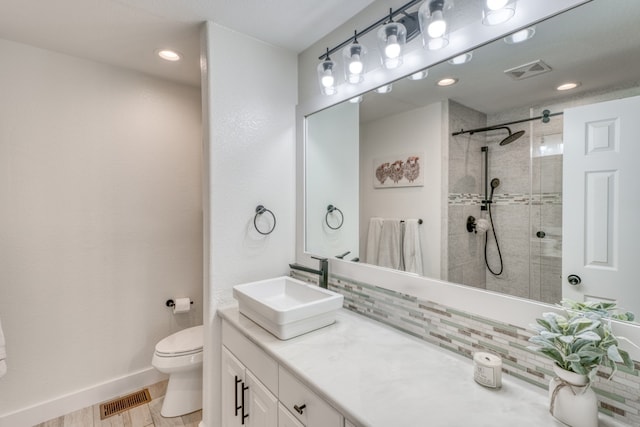 3305 Close Call, Horseshoe Bay, TX 78657 - bathroom with toilet, tiled shower, backsplash, vanity, and baseboards