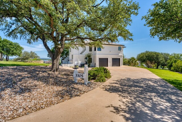 3305 Close Call, Horseshoe Bay, TX 78657 - view of front of house with a garage, driveway, and stucco siding