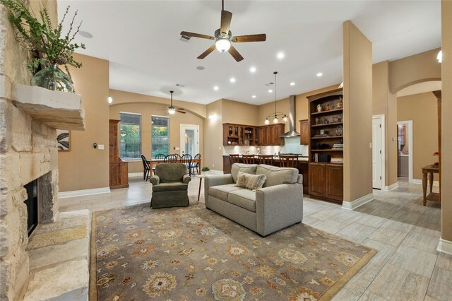 201 Greenridge Ln, Dripping Springs, TX 78620 - living room with arched walkways, a ceiling fan, recessed lighting, a fireplace, and baseboards