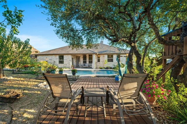 201 Greenridge Ln, Dripping Springs, TX 78620 - rear view of property featuring stone siding, an outdoor pool, a deck, and a chimney