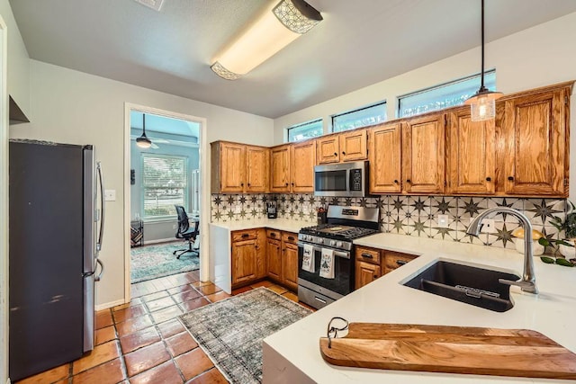 8660 Ephraim Rd, Austin, TX 78717 - kitchen with appliances with stainless steel finishes, a sink, brown cabinets, decorative backsplash, and light countertops