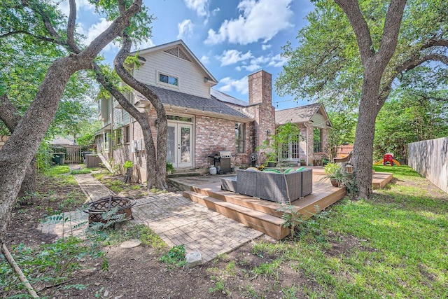 8660 Ephraim Rd, Austin, TX 78717 - rear view of house with french doors, an outdoor living space with a fire pit, a deck, and a fenced backyard