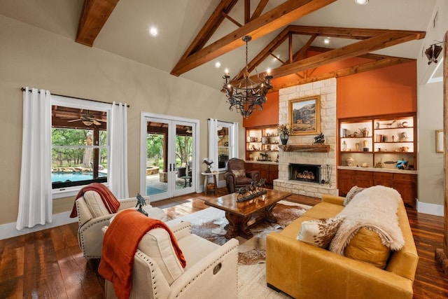 131 Camino Derecho, Wimberley, TX 78676 - living area with beamed ceiling, a stone fireplace, a chandelier, high vaulted ceiling, and french doors