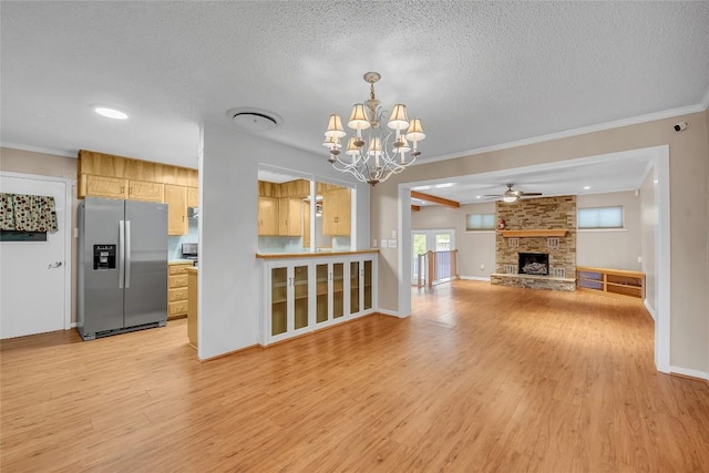 1009 Robertson Ave, Copperas Cove, TX 76522 - unfurnished living room with a chandelier, light wood-type flooring, crown molding, a textured ceiling, and a large fireplace