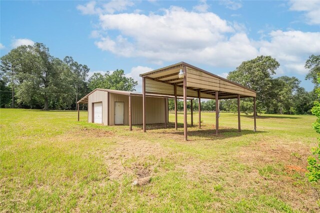 2208 US Highway 96 S, Center, TX 75935 - view of grassy yard featuring a detached garage, an outdoor structure, and driveway