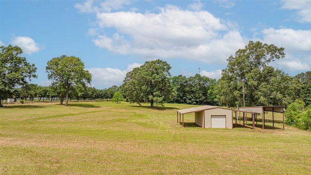 2208 US Highway 96 S, Center, TX 75935 - view of green lawn featuring a detached garage, an outbuilding, and view of wooded area