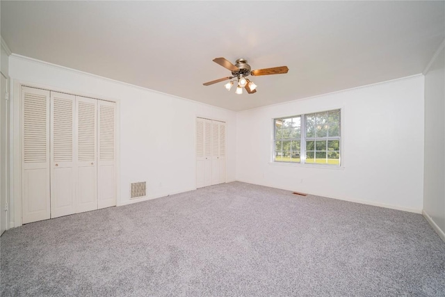 2208 US Highway 96 S, Center, TX 75935 - unfurnished bedroom featuring multiple closets, carpet, ornamental molding, and ceiling fan