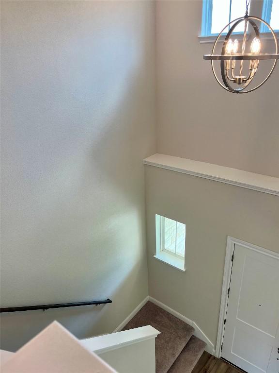 131 Delaware Ln, Kyle, TX 78640 - stairway featuring a chandelier and baseboards