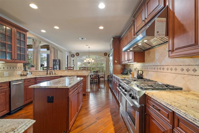 407 Bella Montagna Cir, Austin, TX 78734 - kitchen featuring stainless steel range, under cabinet range hood, a sink, a peninsula, and wood finished floors