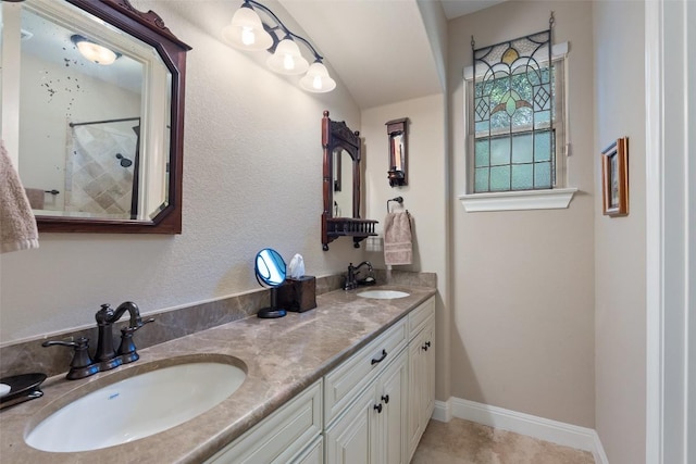 407 Bella Montagna Cir, Austin, TX 78734 - bathroom with double vanity, a tile shower, and baseboards