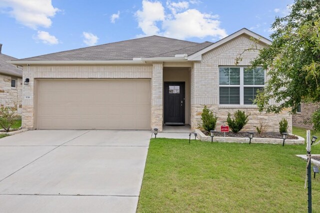 936 Vogel Dr, Georgetown, TX 78626 - single story home featuring a garage, driveway, a front yard, roof with shingles, and brick siding