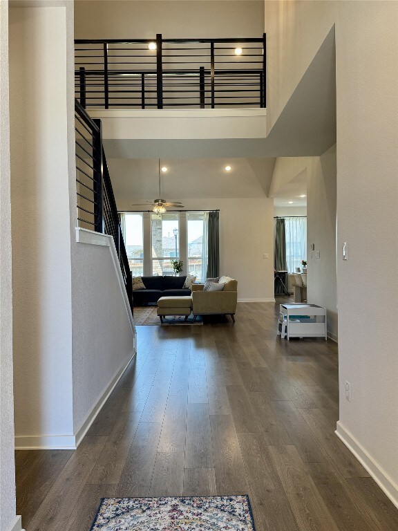 422 Billowing Way, Kyle, TX 78640 - hall with baseboards, healthy amount of natural light, a high ceiling, wood finished floors, and stairway