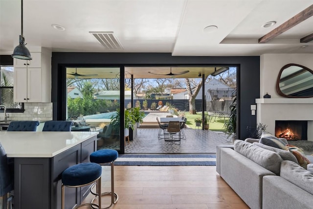 1102 Kinney Ave, Austin, TX 78704 - living area featuring light wood-style flooring, a ceiling fan, a lit fireplace, and recessed lighting