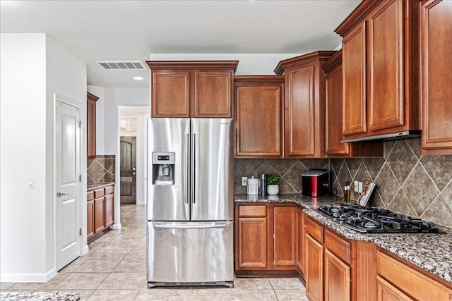 295 Desert Wilow Way, Austin, TX 78737 - kitchen featuring stainless steel fridge, black gas stovetop, dark stone counters, tasteful backsplash, and light tile patterned floors