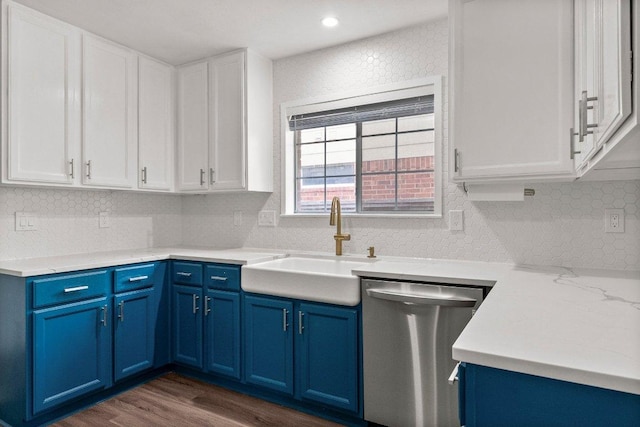 11220 Amaranth Ln, Austin, TX 78754 - kitchen with stainless steel dishwasher, blue cabinets, a sink, dark wood-style flooring, and white cabinets