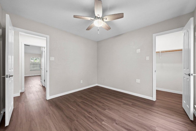 11220 Amaranth Ln, Austin, TX 78754 - unfurnished bedroom with dark wood-type flooring, baseboards, a walk in closet, a closet, and a ceiling fan