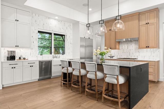 12625 Maidenhair Ln Unit 32, Austin, TX 78738 - kitchen with stainless steel appliances, tasteful backsplash, a center island, a kitchen bar, and recessed lighting