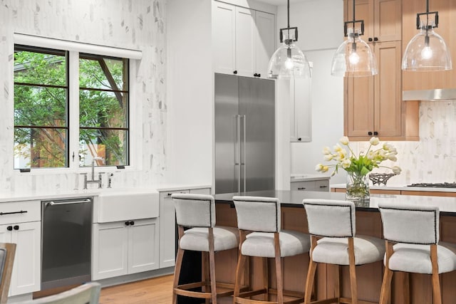 12625 Maidenhair Ln Unit 32, Austin, TX 78738 - kitchen with stainless steel appliances, a breakfast bar area, decorative light fixtures, and tasteful backsplash
