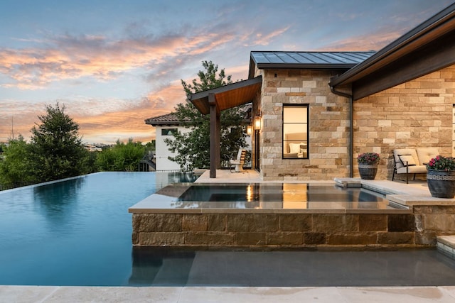 12625 Maidenhair Ln Unit 32, Austin, TX 78738 - pool at dusk with an in-ground hot tub and an infinity pool