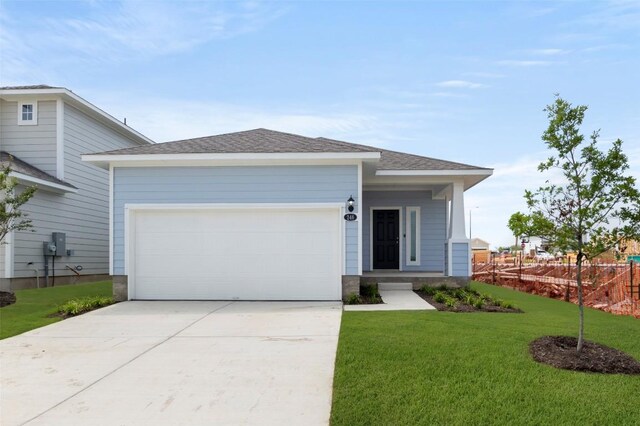 246 Barley Ln, Elgin, TX 78621 - view of front of house with a front yard, concrete driveway, an attached garage, and roof with shingles