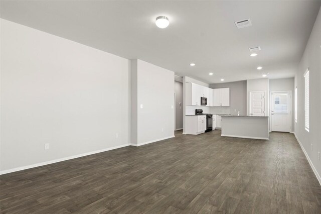246 Barley Ln, Elgin, TX 78621 - unfurnished living room featuring dark wood-style floors and recessed lighting