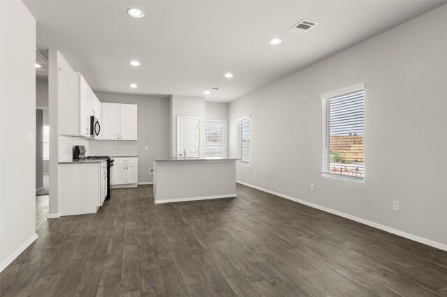 246 Barley Ln, Elgin, TX 78621 - kitchen with gas range, dark wood-type flooring, recessed lighting, an island with sink, and white cabinetry
