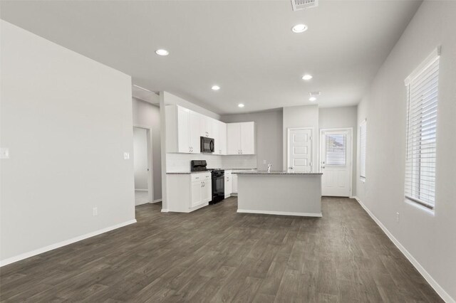 246 Barley Ln, Elgin, TX 78621 - kitchen with black appliances, dark wood finished floors, white cabinets, a center island with sink, and recessed lighting