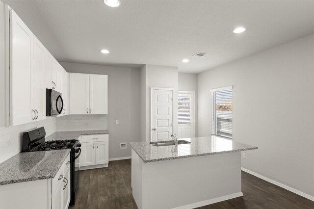 246 Barley Ln, Elgin, TX 78621 - kitchen featuring black appliances, decorative backsplash, dark wood finished floors, light stone counters, and recessed lighting