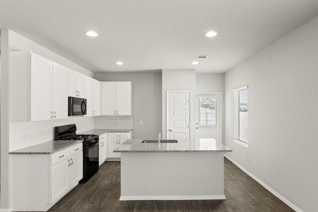 246 Barley Ln, Elgin, TX 78621 - kitchen featuring black appliances, light stone countertops, an island with sink, backsplash, and recessed lighting