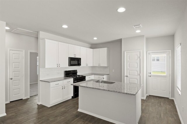 246 Barley Ln, Elgin, TX 78621 - kitchen with black appliances, tasteful backsplash, dark wood-style floors, light stone countertops, and white cabinets