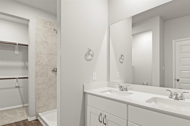 246 Barley Ln, Elgin, TX 78621 - full bathroom with double vanity, wood finished floors, tiled shower, and a spacious closet