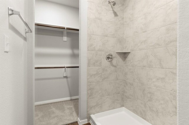 246 Barley Ln, Elgin, TX 78621 - bathroom featuring a tile shower and a walk in closet