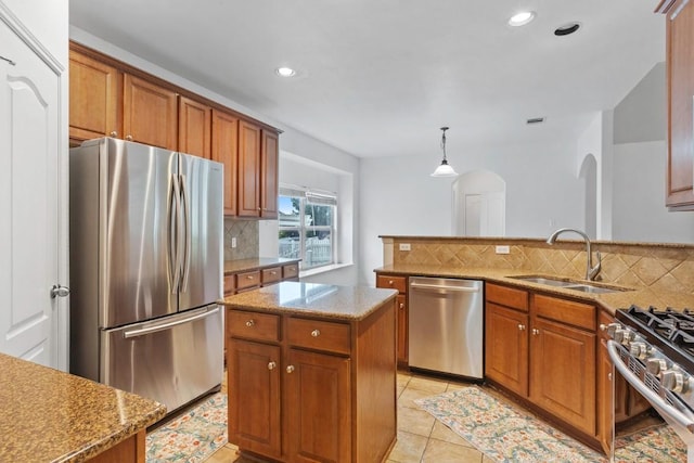 221 Mcgarity St, Kyle, TX 78640 - kitchen with stainless steel appliances, a sink, brown cabinets, backsplash, and recessed lighting