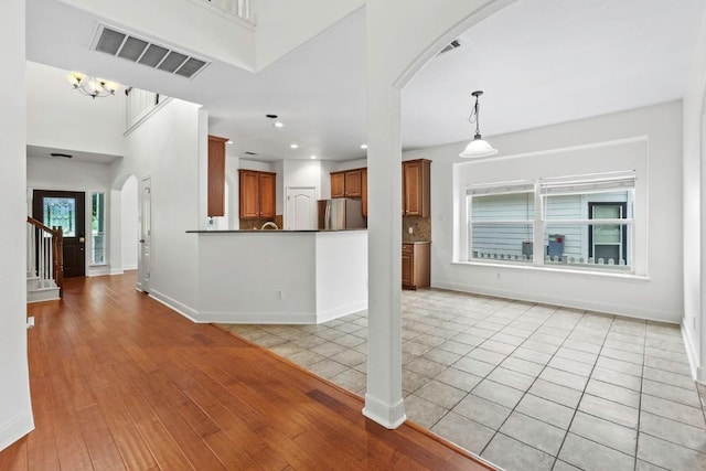 221 Mcgarity St, Kyle, TX 78640 - unfurnished living room with arched walkways, baseboards, stairway, and recessed lighting