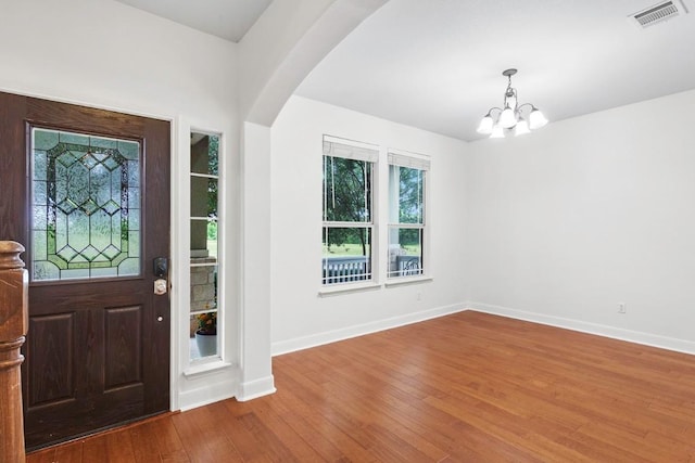 221 Mcgarity St, Kyle, TX 78640 - foyer entrance with a chandelier, wood finished floors, baseboards, and arched walkways