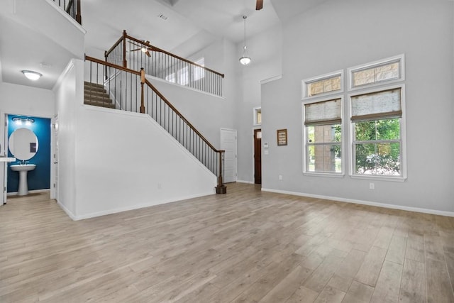 1913 Gabrielles Way, Manchaca, TX 78652 - unfurnished living room featuring stairs, a high ceiling, wood finished floors, baseboards, and ceiling fan