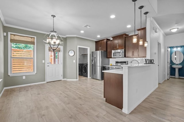 1913 Gabrielles Way, Manchaca, TX 78652 - kitchen with appliances with stainless steel finishes, washer and dryer, light countertops, tasteful backsplash, and baseboards