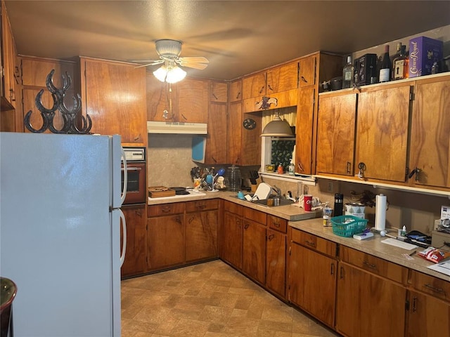 137 N Kowald Ln, New Braunfels, TX 78130 - kitchen featuring white appliances, a ceiling fan, under cabinet range hood, and brown cabinetry