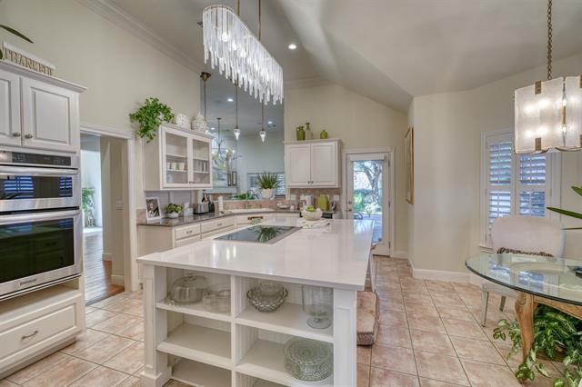 104 Mason Ct, Horseshoe Bay, TX 78657 - kitchen with black electric stovetop, open shelves, double oven, white cabinetry, and ornamental molding